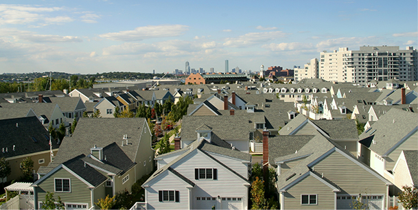 An aerial view of a Boston suburb showing the city skyline in the distance.